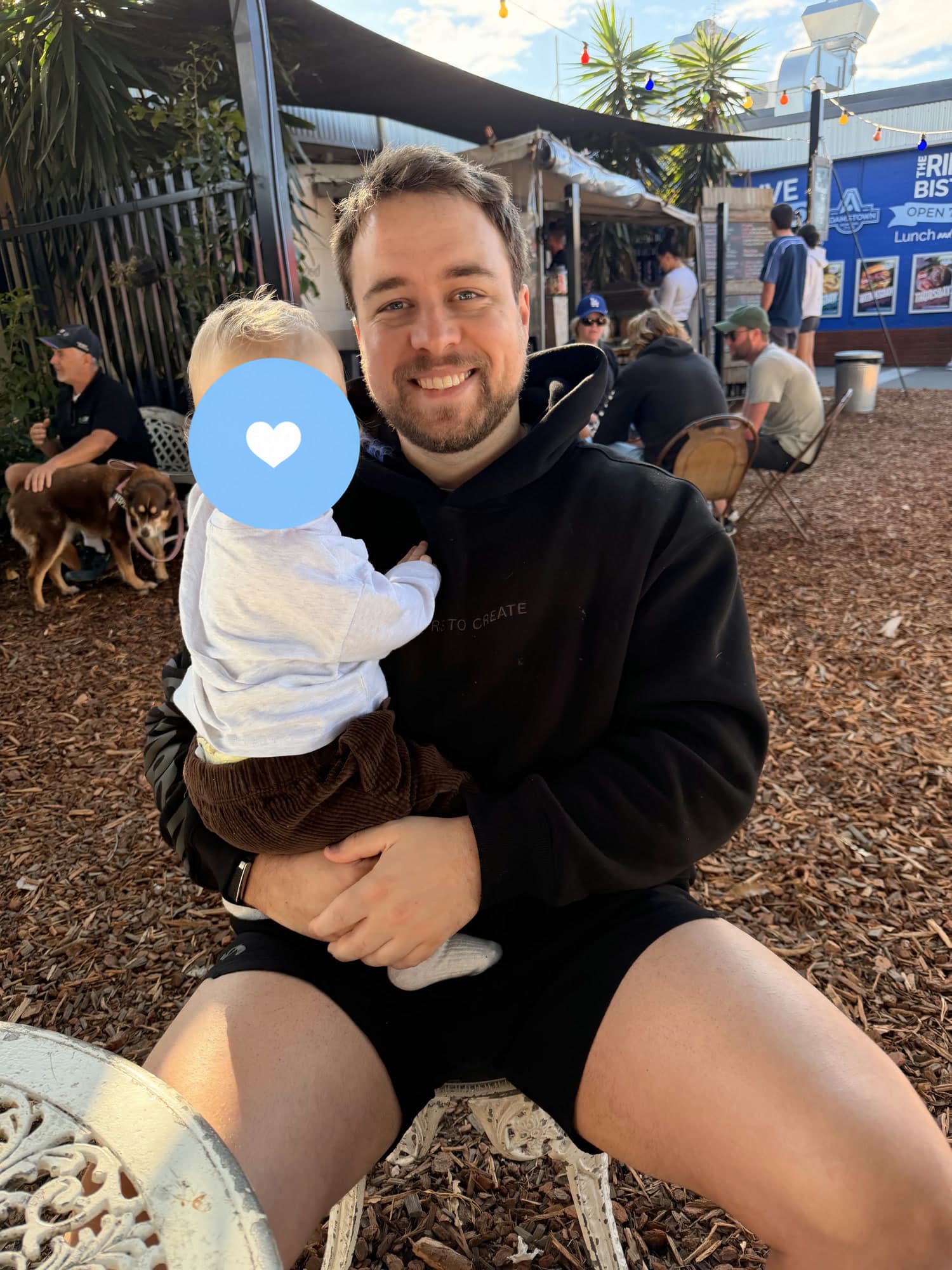 Ty holding his son, with his son’s face covered for privacy